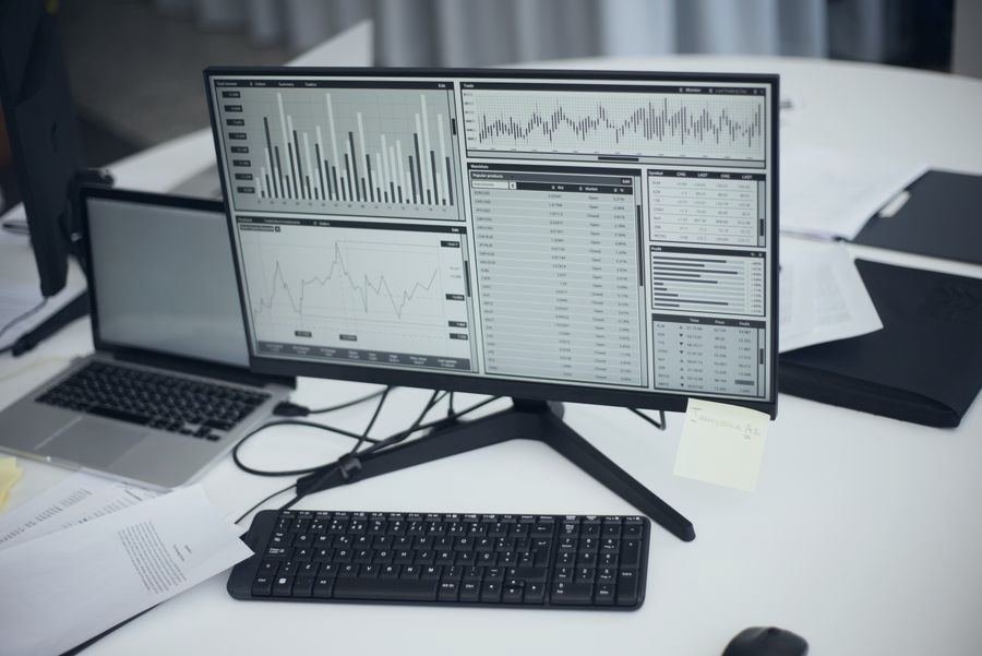 Monitor with charts and data tables on a desk
