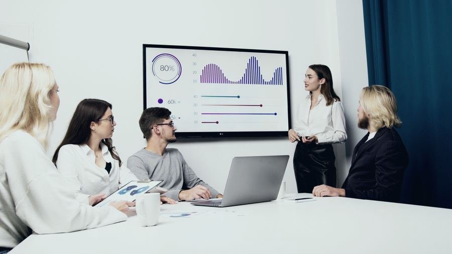 Team meeting in front of a dashboard screen